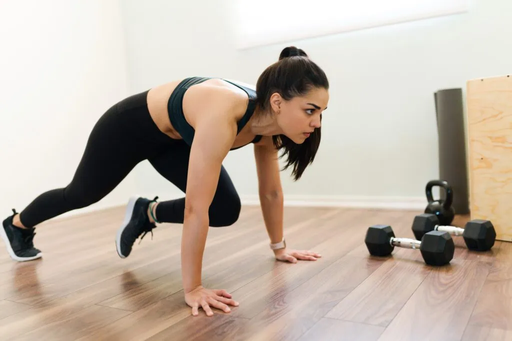 exercising home with high intensity interval training program fitness woman doing mountain climbers cardio workout